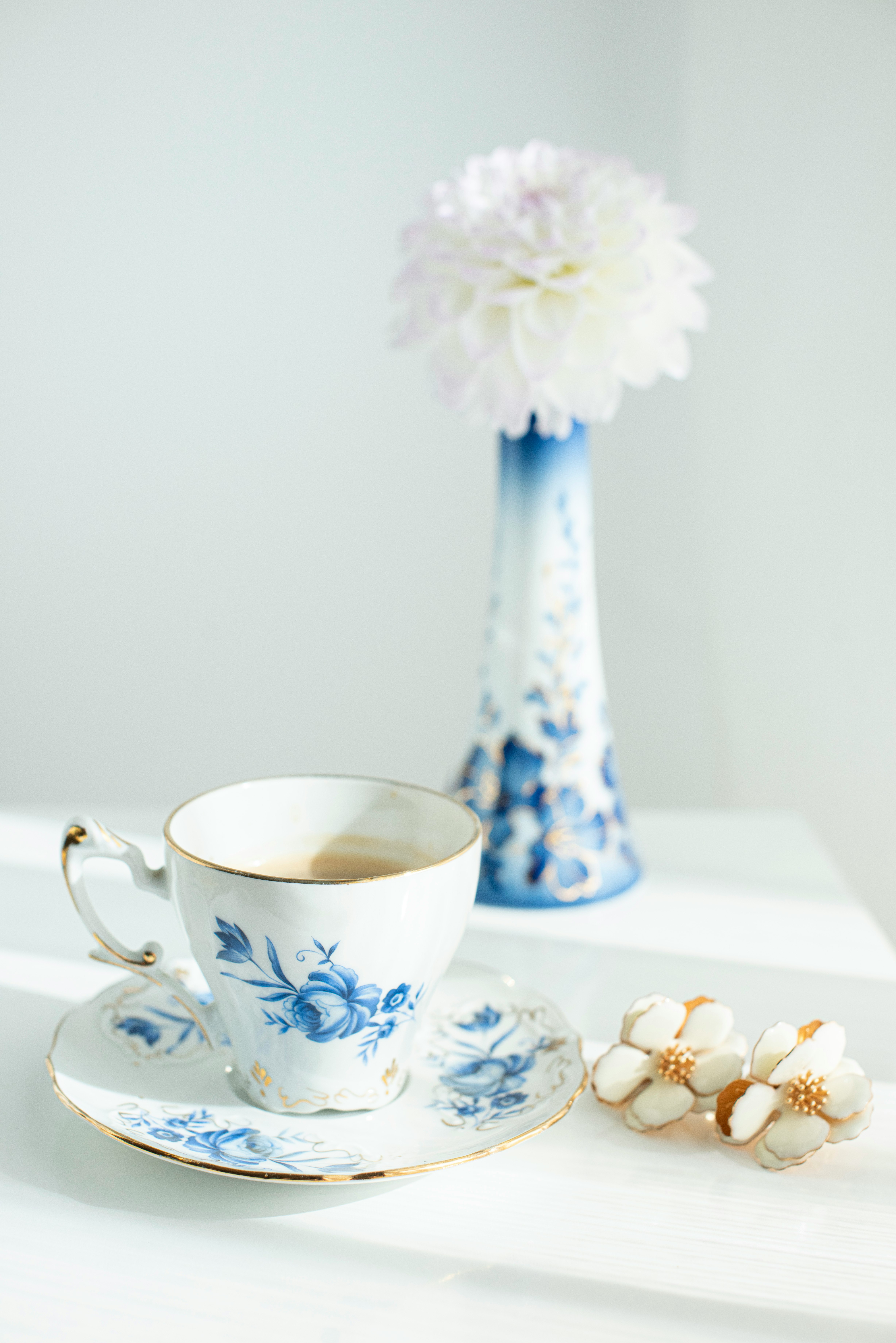 white and blue floral ceramic teacup on saucer